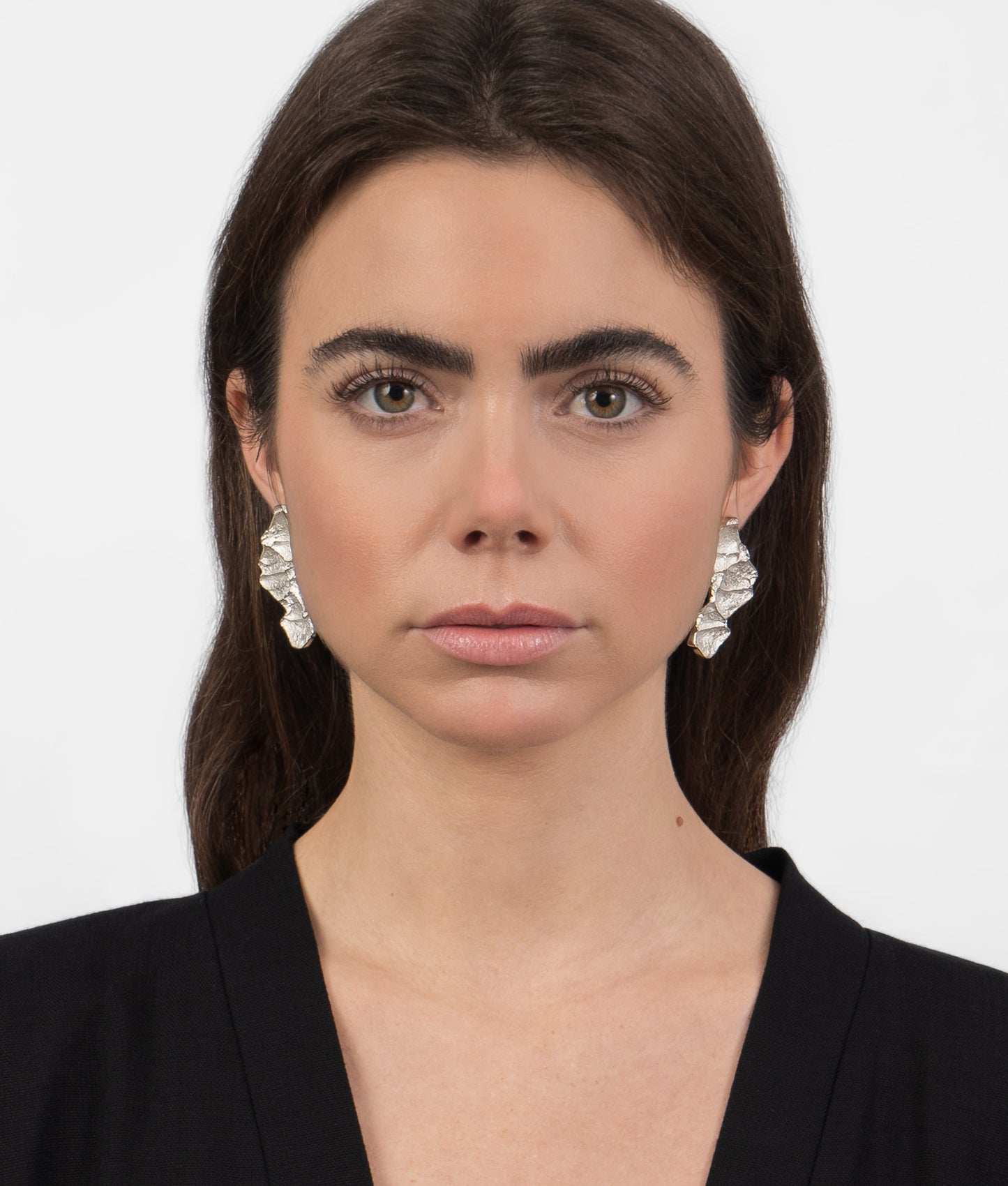 Mujer modelo vistiendo unos pendientes de plata con diseño orgánico de hojas