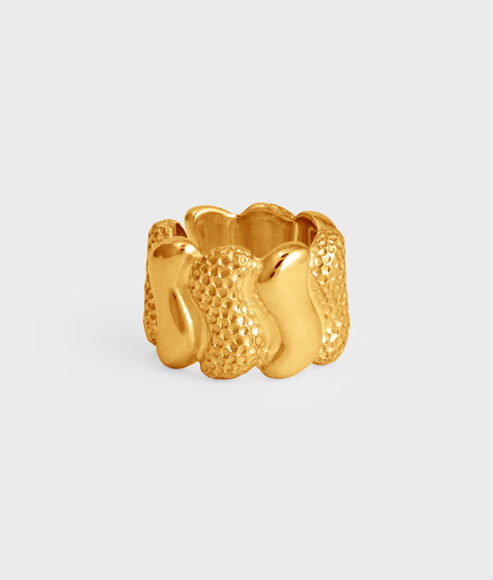 anillo ancho de plata de ley chapado en oro con un diseño de piezas brillantes y texturizadas a golpe de martillo