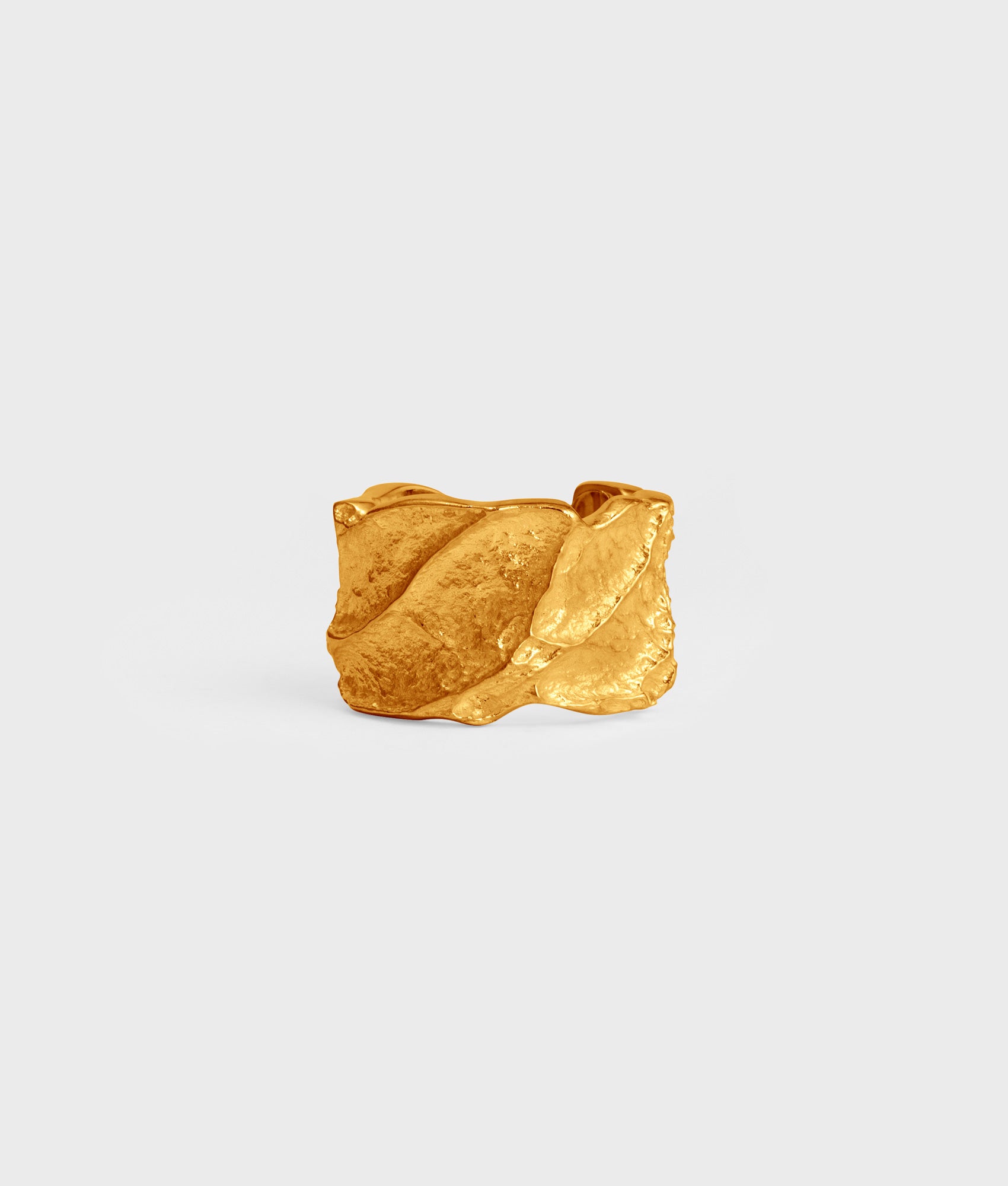 Anillo artesanal de plata de ley bañado en oro de 18k con texturas orgánicas y un toque de fantasía.