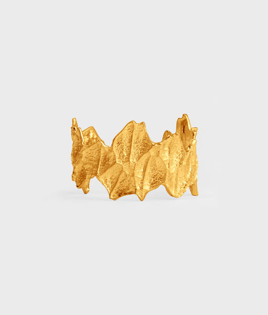 Brazalete artesanal de plata de ley 925 con baño de oro de 18k. Esta pieza muestra una línea de diseño con formas y texturas orgánicas